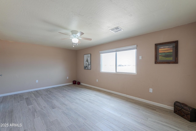 spare room featuring ceiling fan, light hardwood / wood-style flooring, and a textured ceiling