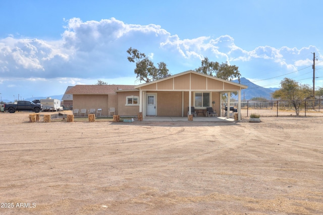 rear view of property with a mountain view and a patio area