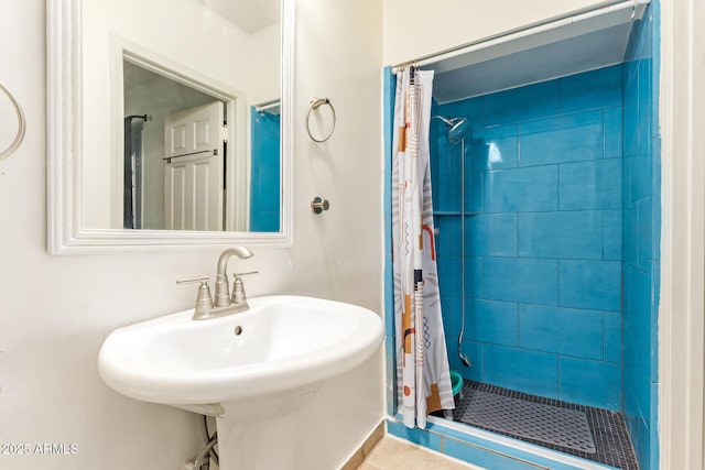 bathroom with a stall shower, a sink, and tile patterned floors