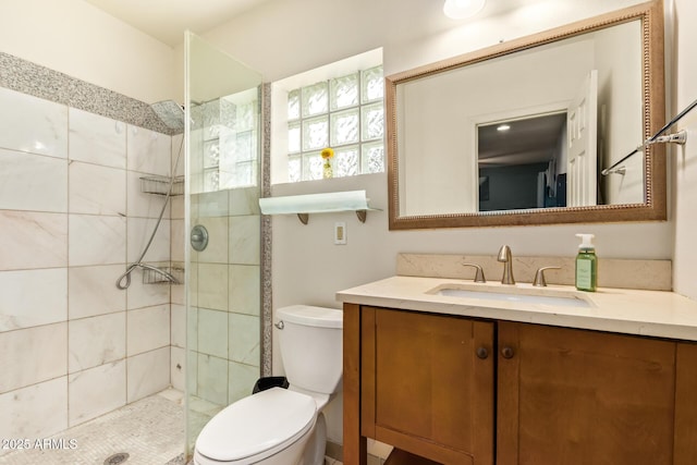 full bath featuring toilet, a tile shower, and vanity