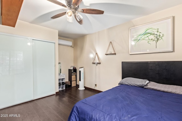 bedroom featuring a wall mounted AC, wood finished floors, ceiling fan, baseboards, and a closet