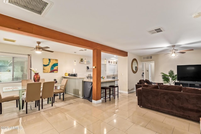 living room featuring ceiling fan, light tile patterned flooring, and baseboards