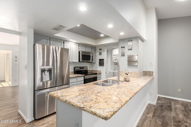 2059 E Brown Rd Unit 35, Mesa, AZ 85213 - kitchen featuring stainless steel appliances, a peninsula, wood finished floors, light stone counters, and recessed lighting