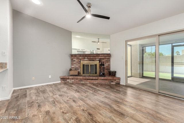 2059 E Brown Rd Unit 35, Mesa, AZ 85213 - unfurnished living room featuring a ceiling fan, wood finished floors, and a brick fireplace