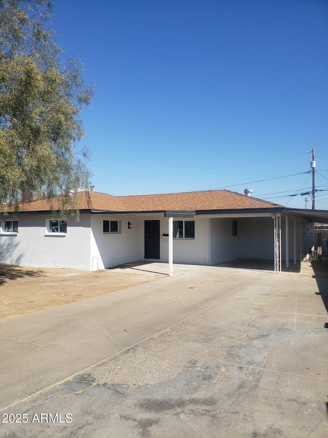 ranch-style home with a carport and driveway