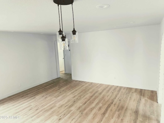 empty room featuring light wood finished floors and baseboards