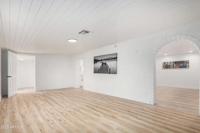 unfurnished room featuring arched walkways, wooden ceiling, visible vents, and light wood finished floors