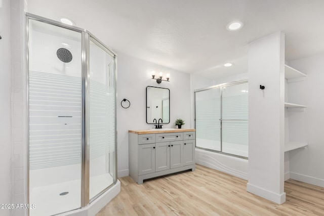 bathroom with recessed lighting, baseboards, wood finished floors, and vanity
