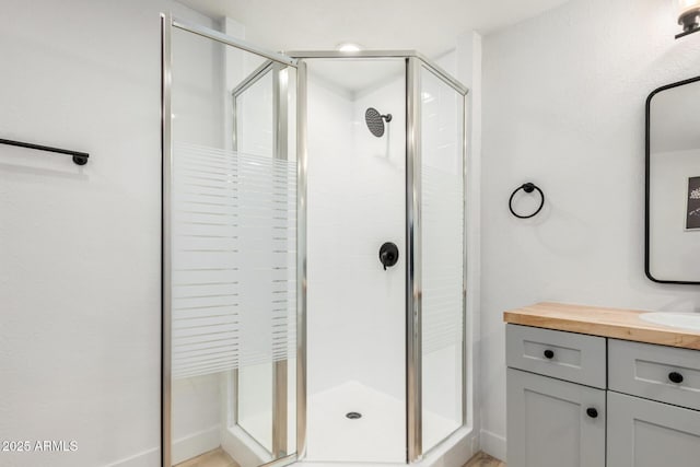 bathroom with a shower stall and vanity