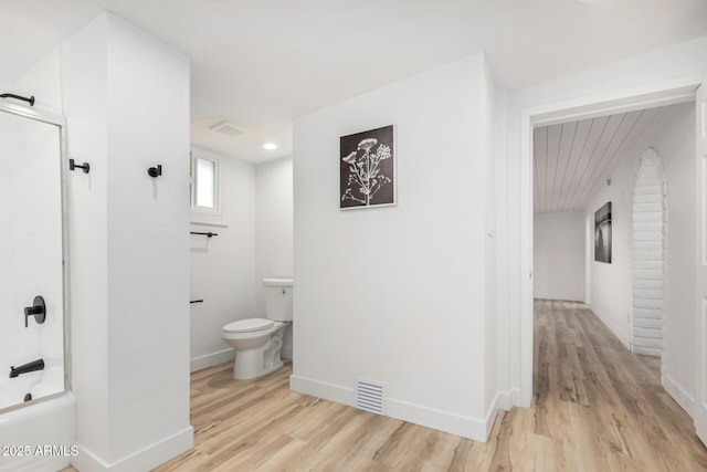bathroom with toilet, wood finished floors, visible vents, and baseboards
