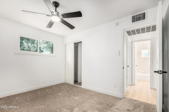 unfurnished bedroom with a closet, visible vents, baseboards, and carpet flooring