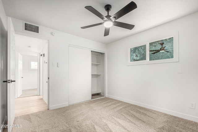 unfurnished bedroom with a closet, carpet, visible vents, and baseboards