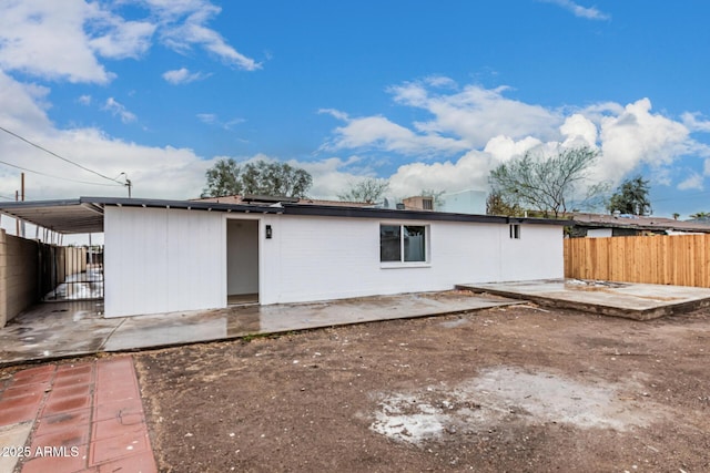 rear view of property with fence and a patio