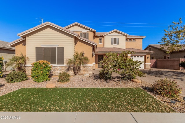 view of front of home with brick siding, fence, decorative driveway, and a front yard