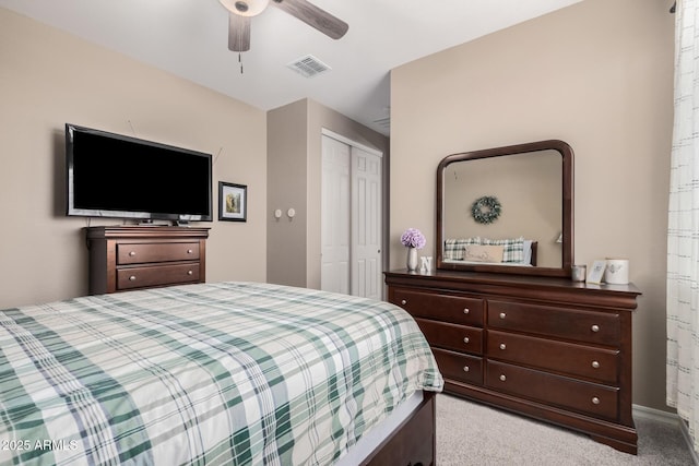 bedroom featuring a ceiling fan, a closet, visible vents, and light carpet