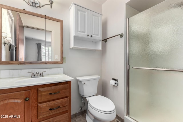 full bathroom featuring a stall shower, toilet, and vanity