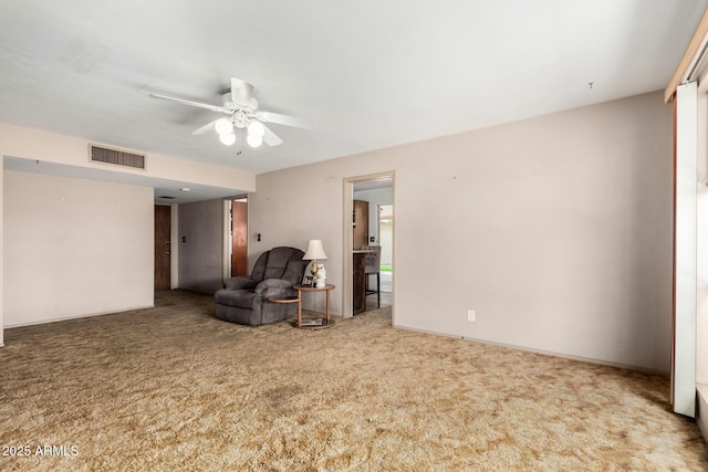 sitting room featuring a ceiling fan and carpet
