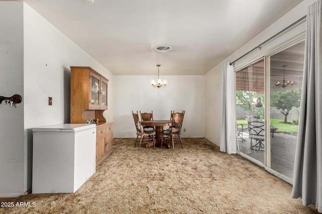 dining area featuring a chandelier and light carpet