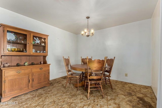 dining room featuring a chandelier and carpet floors