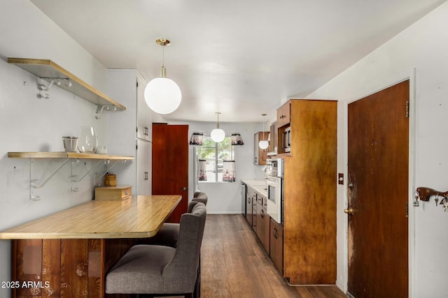 kitchen with open shelves, dark wood-style floors, light countertops, appliances with stainless steel finishes, and brown cabinets