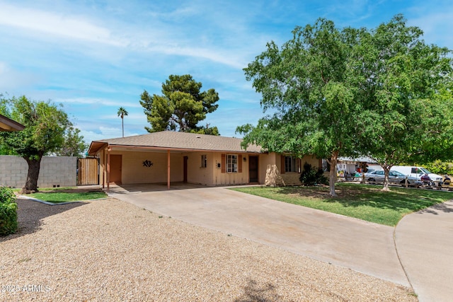 ranch-style home with a carport, concrete driveway, and a gate