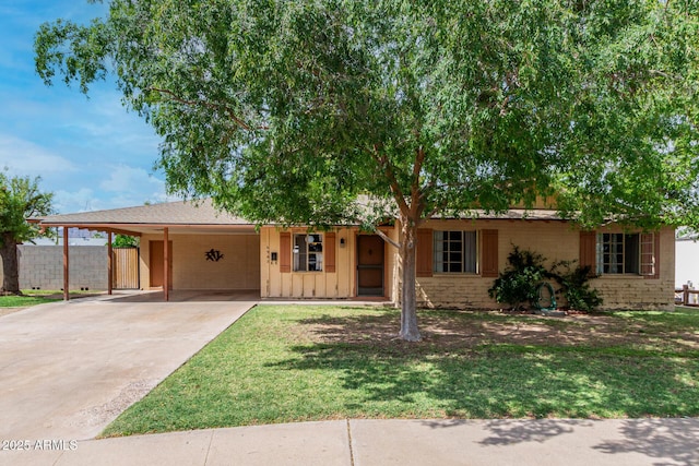 ranch-style home with an attached carport, driveway, and board and batten siding