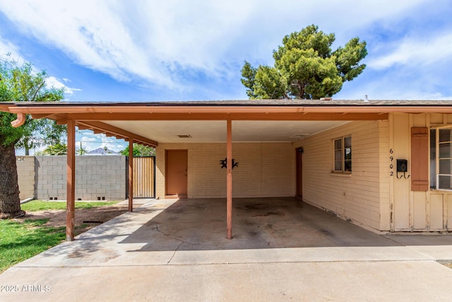 view of car parking featuring fence, an attached carport, and concrete driveway