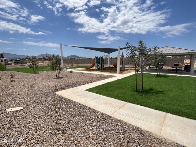 view of play area featuring a gazebo, a mountain view, and a lawn