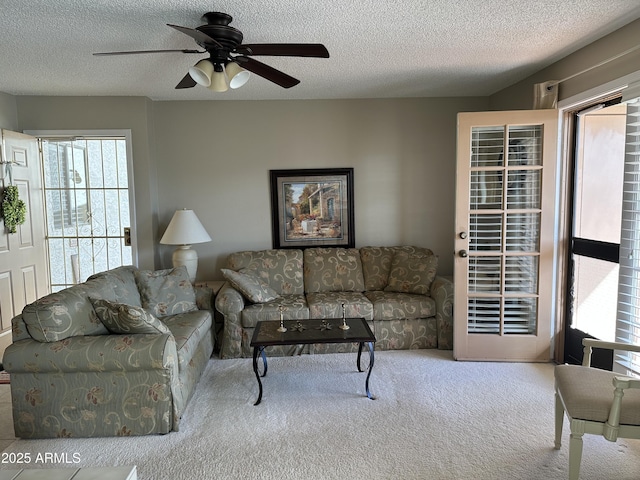 carpeted living room with ceiling fan and a textured ceiling