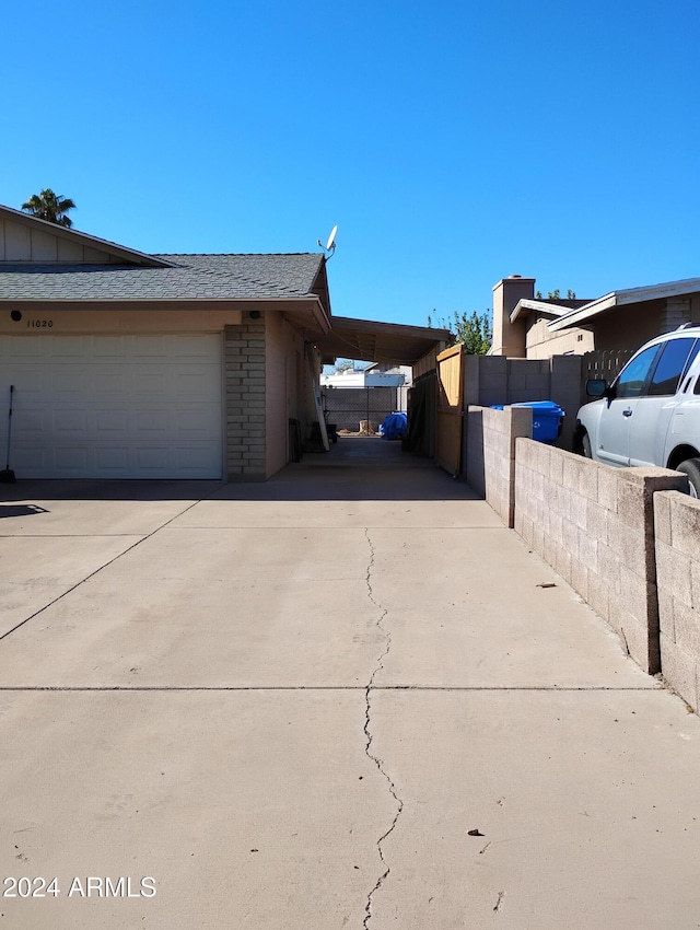 view of side of property featuring a garage and a carport