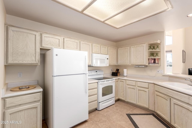 kitchen with light tile patterned flooring, white appliances, sink, and light brown cabinets