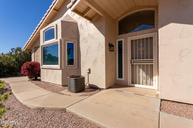 property entrance featuring central AC unit and a patio