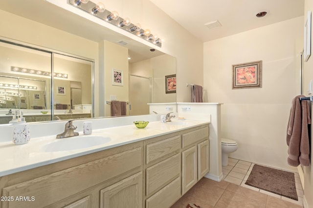 bathroom with tile patterned floors, toilet, a shower with shower door, and vanity