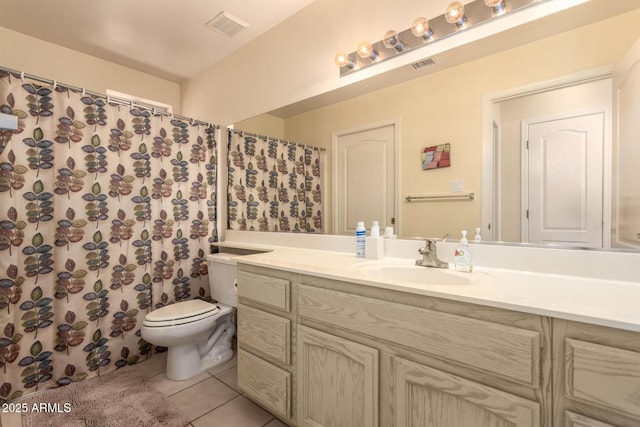 bathroom with tile patterned flooring, vanity, and toilet