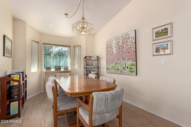 dining area featuring an inviting chandelier and light hardwood / wood-style floors