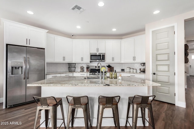 kitchen featuring an island with sink, stainless steel appliances, sink, and white cabinets