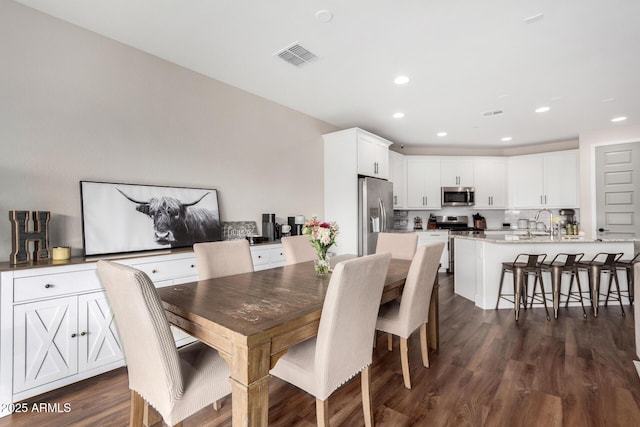 dining space with dark hardwood / wood-style flooring and sink