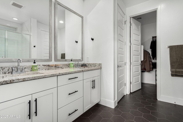 bathroom with tile patterned floors, vanity, and an enclosed shower