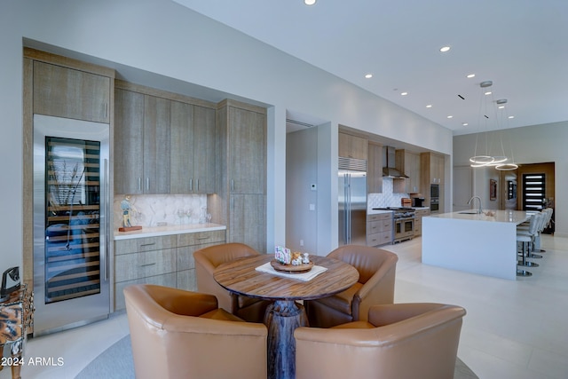 dining area featuring beverage cooler, sink, and light tile patterned flooring