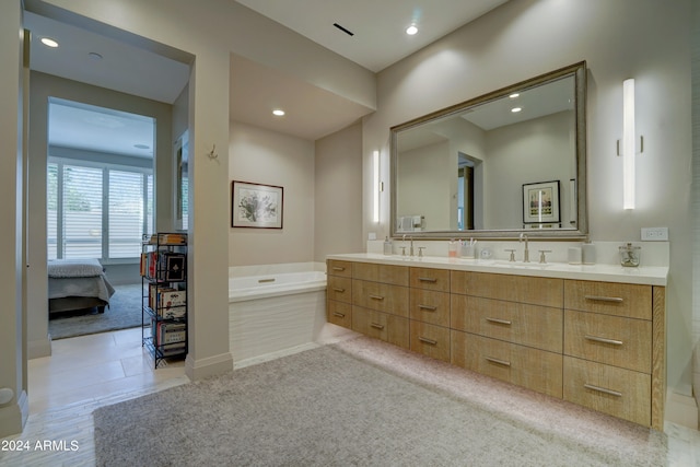 bathroom with vanity and tiled bath