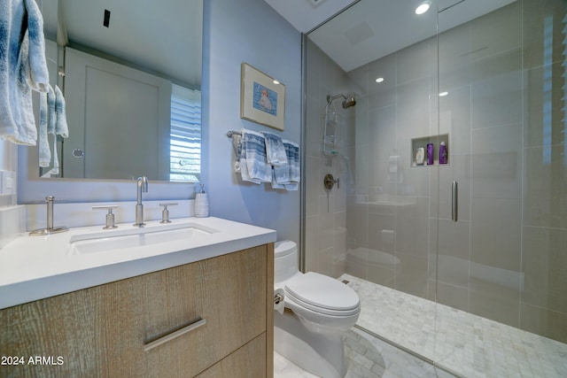 bathroom featuring walk in shower, vanity, and toilet