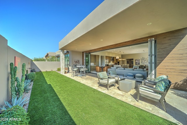 rear view of house with an outdoor living space, a yard, and a patio area