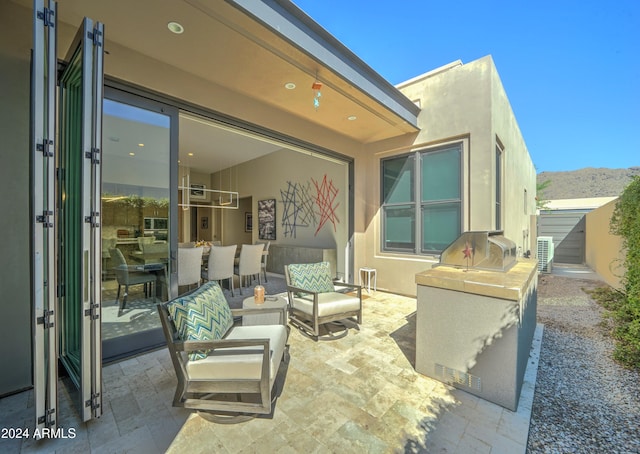 view of patio featuring outdoor lounge area, a mountain view, and area for grilling