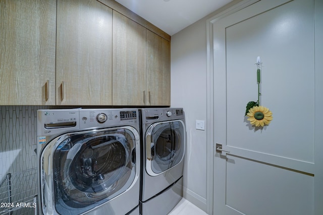 laundry area with cabinets and washer and clothes dryer