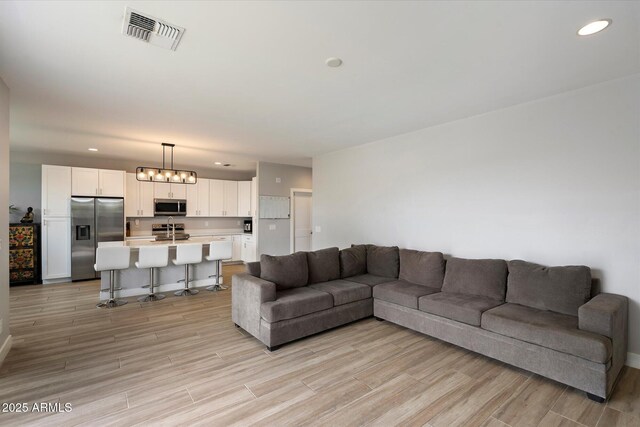 2604 N 27th St Unit 4, Phoenix, AZ 85008 - living room featuring light wood-style floors, baseboards, and recessed lighting