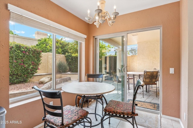 dining space featuring a chandelier, a textured wall, and baseboards