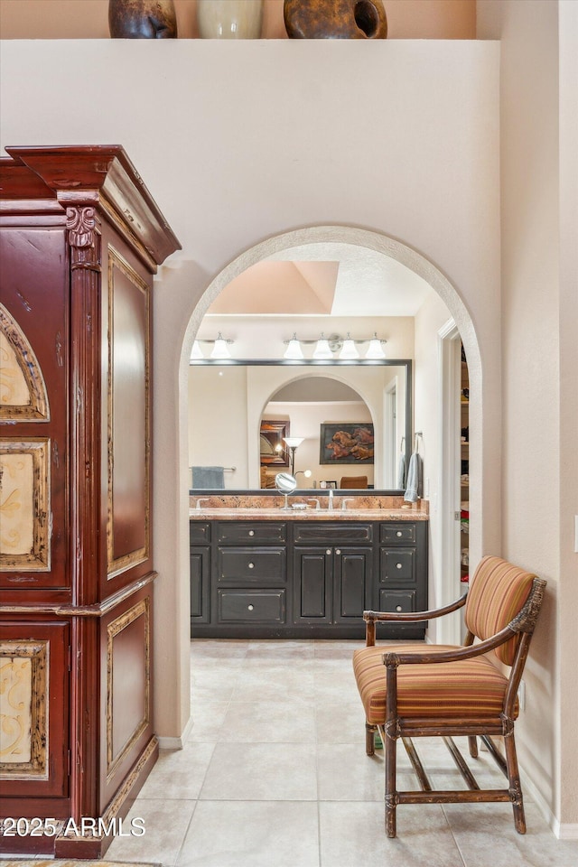 bathroom with a towering ceiling, tile patterned flooring, and vanity