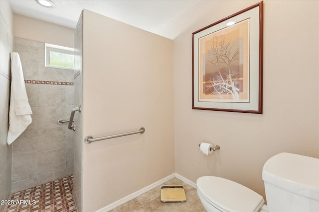 full bath with baseboards, tiled shower, and toilet