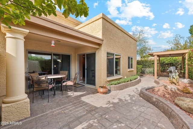 back of house featuring a patio, outdoor dining area, fence, and stucco siding