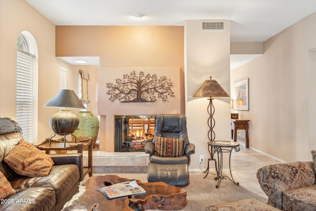 living room featuring baseboards, visible vents, and a multi sided fireplace